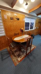 a dining room table with a vase of flowers on it at Depto. Altos de Tenglo in Puerto Montt