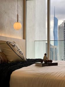 - une chambre avec un lit, un livre et une fenêtre dans l'établissement Quill Residence KLCC by Hausome, à Kuala Lumpur