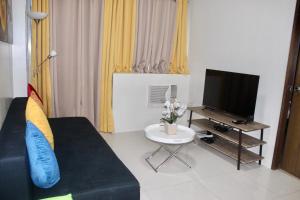 a living room with a couch and a tv at Condo Palm Tree 1 Across NAIA T3 in Manila