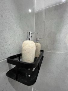 a bathroom with two soap dispensers on a wall at Brahmastra Bali villa in Kubupenlokan