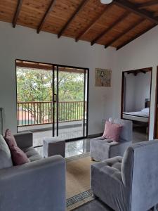 sala de estar con 2 sofás y balcón en Hermosa casa de campo el Peñol,Guatapé, en Guatapé
