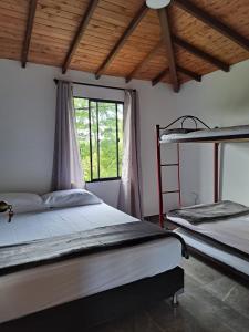 1 dormitorio con 2 literas y ventana en Hermosa casa de campo el Peñol,Guatapé, en Guatapé