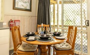 una mesa de comedor con tazones y platos. en The Crays Accommodation, en Strahan