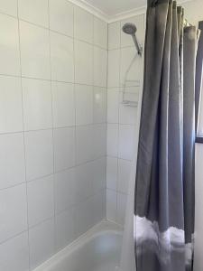 ein Badezimmer mit einem Duschvorhang und einer Badewanne in der Unterkunft Cabaña Raihuè Austral in Puerto Montt