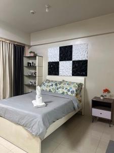 a bedroom with a bed with a black and white quilt at Condo Palm Tree 1 Across NAIA T3 in Manila