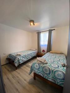1 Schlafzimmer mit 2 Betten und einem Fenster in der Unterkunft Cabaña Raihuè Austral in Puerto Montt