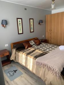 ein Schlafzimmer mit einem großen Bett und Holzboden in der Unterkunft Cabaña Raihuè Austral in Puerto Montt