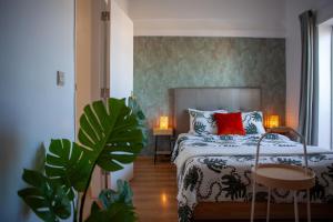 a bedroom with a bed with red pillows and plants at Just4u Apartment 2 in Almada