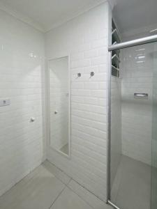 ein weißes Bad mit einer Dusche und einem Spiegel in der Unterkunft Apt. inteiro recém-reformado - Campos Elíseos in São Paulo