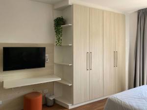 1 dormitorio con TV y armarios blancos en Apt. inteiro recém-reformado - Campos Elíseos, en São Paulo