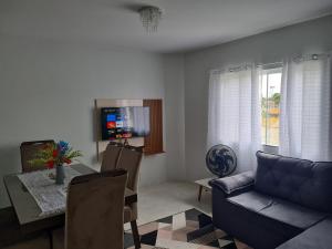 - un salon avec un canapé, une table et une télévision dans l'établissement Ap 03 edificio Sao Paulo I, à Ponta Grossa
