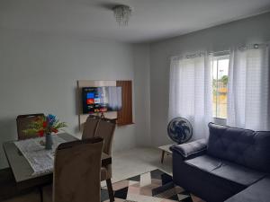 a living room with a couch and a table and a television at Ap 03 edificio Sao Paulo I in Ponta Grossa