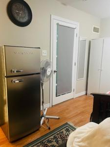 a room with a refrigerator and a clock on the wall at RoseT in Halifax