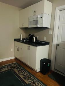 a kitchen with white cabinets and a microwave at RoseT in Halifax