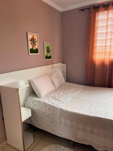 Habitación pequeña con cama y ventana en casa sao pedro da aldeia en São Pedro da Aldeia