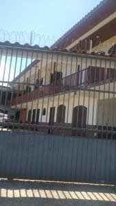 a fence in front of a building with windows at Kitnet em Matinhos PR Balneário Riviera in Matinhos