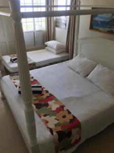 New Mavida Lodge في Levuka: غرفة نوم بسريرين وسرير مظلة