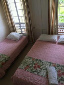 2 Betten in einem Zimmer mit Fenster in der Unterkunft New Mavida Lodge in Levuka