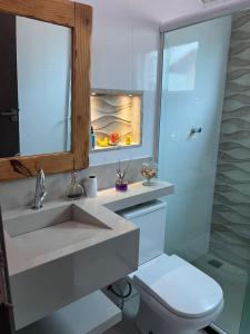 a bathroom with a sink and a toilet and a mirror at casa sao pedro da aldeia in São Pedro da Aldeia