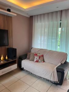 a living room with a couch and a television at casa sao pedro da aldeia in São Pedro da Aldeia