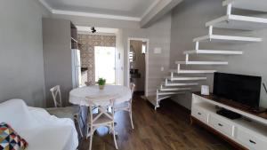 a living room with a table and a staircase at Excelente Sobrado Confortável no Centro de Tijucas Próximo as Praias in Tijucas