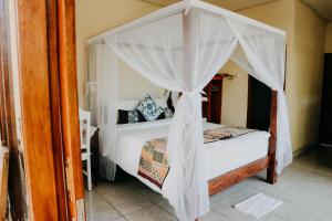 a bedroom with a bed with a canopy at Padi Bali Jatiluwih in Tabanan