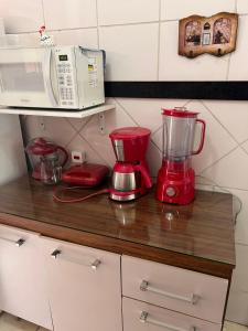 a kitchen counter with a blender and a microwave at casa sao pedro da aldeia in São Pedro da Aldeia