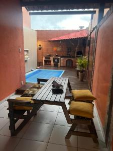 un patio con una mesa y una piscina en casa sao pedro da aldeia, en São Pedro da Aldeia