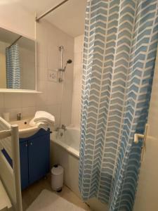 a bathroom with a sink and a shower curtain at Le Chêne: medieval district city centre in Poitiers