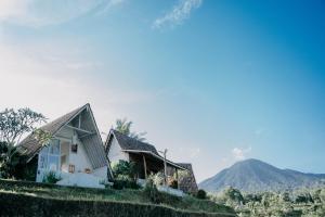 a house on a hill with a mountain in the background at Padi Bali Jatiluwih in Tabanan