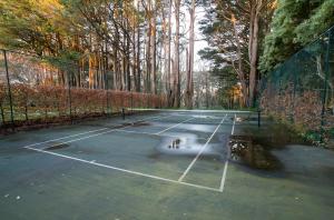 a tennis court with water on top of it at Moulton Park Estate - Cottages in Sassafras