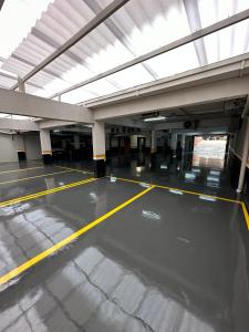 an empty parking garage with a yellow line on the floor at Play Hotel Águas Claras in Taguatinga