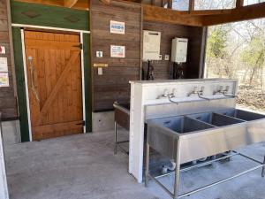 a bathroom with a sink and a wooden door at -be- Kita Karuizawa Camp Field - Vacation STAY 42270v in Kita-karuizawa