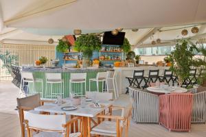 ドバイにあるMarriott Resort Palm Jumeirah, Dubaiのテーブルと椅子のあるレストラン、バー