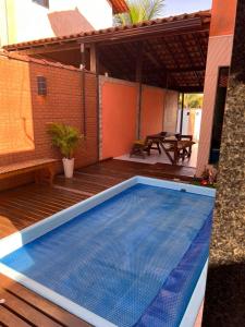 una piscina en una terraza con una casa en casa sao pedro da aldeia, en São Pedro da Aldeia