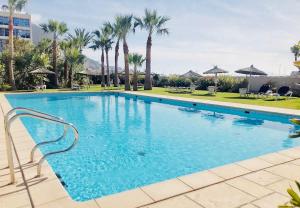 una gran piscina con palmeras en el fondo en Lovely & Cosy Deluxe Home in Gibraltar en Gibraltar