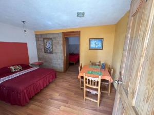 a bedroom with a bed and a table in it at Hotel El Mirador y Jardin in Tlayacapan