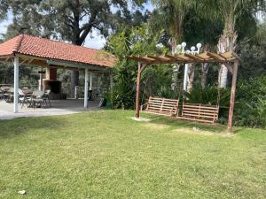a wooden pergola with a table and chairs in a yard at Hotel El Mirador y Jardin in Tlayacapan