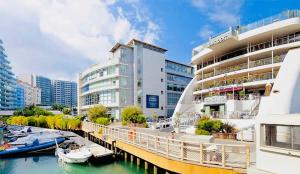 un gran edificio junto a un puerto deportivo con barcos en el agua en Lovely & Cosy Deluxe Home in Gibraltar en Gibraltar