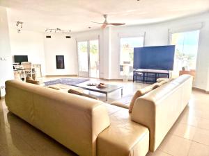 a living room with a large couch and a tv at Villa Marion in San Fulgencio