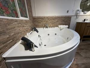 uma banheira branca na casa de banho com um lavatório em New York Suites em Viña del Mar