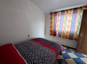 Habitación pequeña con cama y ventana en Casa completa a 10 min de Teziutlan., 