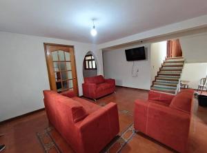 Sala de estar con 2 sofás rojos y TV en Casa completa a 10 min de Teziutlan., 
