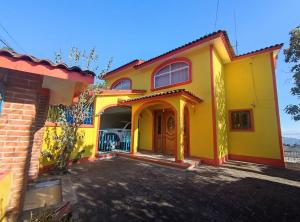 una casa amarilla con una entrada delante de ella en Casa completa a 10 min de Teziutlan., 