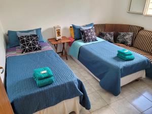 a room with two beds and a couch at Casa Carlos Paz a los pies de la montaña in Villa Carlos Paz
