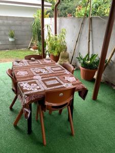 ein Tisch mit einem Tischtuch darauf mit Pflanzen in der Unterkunft Bungalow climatisé chez Kim in Taputapuapea
