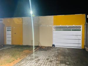 un garaje con dos puertas blancas y un semáforo en Lugar de paz, en Paraipaba