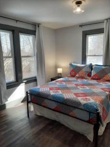 a bedroom with a bed with a quilt on it at Country Haven-Dog Friendly, 6 bed 3 bath Farmhouse, Jacuzzi Tub, Firepit, Games, Large private yard! in South Haven