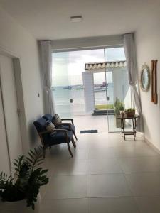 a living room with a view of the ocean at Casa pé na areia em Gamboa do Morro de São Paulo in Cayru