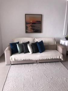 a couch with pillows on it in a living room at Casa pé na areia em Gamboa do Morro de São Paulo in Cayru